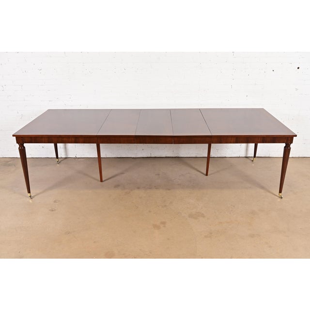An exceptional French Regency Louis XVI style extension dining table By Kindel Furniture USA, Circa 1980s Gorgeous book-...