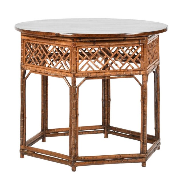 A bamboo fretwork center table crafted in the Chinoiserie style, constructed of bamboo and wood with a warm honey-toned...
