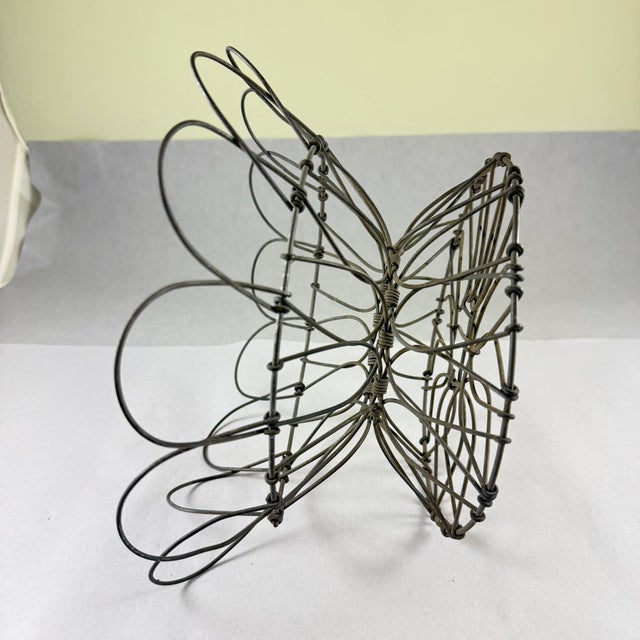 From France, a hand-made Fil de Fer, iron wire egg basket, circa 1890 – 1910. A round, petal top footed, folding basket...