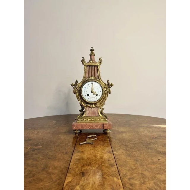 Unusual antique Victorian quality French mantle clock, having an unusual shaped ornate gilded metal and pink marble case...