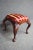 Carved Mahogany footstool, Queen Anne style with burgundy upholstery.