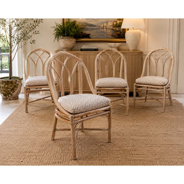 A beautiful set of four vintage Cathedral dining chairs by McGuire of San Francisco. Crafted from rattan with McGuire’s...