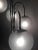 This table lamp in chromed tubular metal features four white spherical glass diffusers with a cracked effect. European...