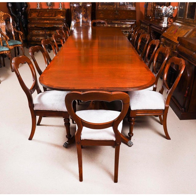 This is an elegant vintage dining set that comprises a Regency Revival triple pillar dining table, dating from the mid...