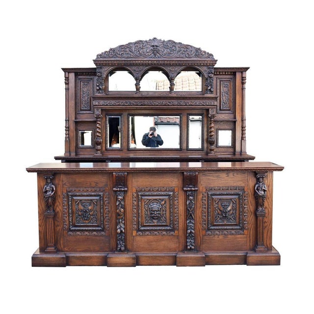 A superb late 19th-century carved oak front and back bar of impressive scale and craftsmanship. Richly detailed...