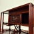 A finely crafted Chinese display cabinet made from richly toned rosewood (hongmu), with a deep reddish-brown luster and...
