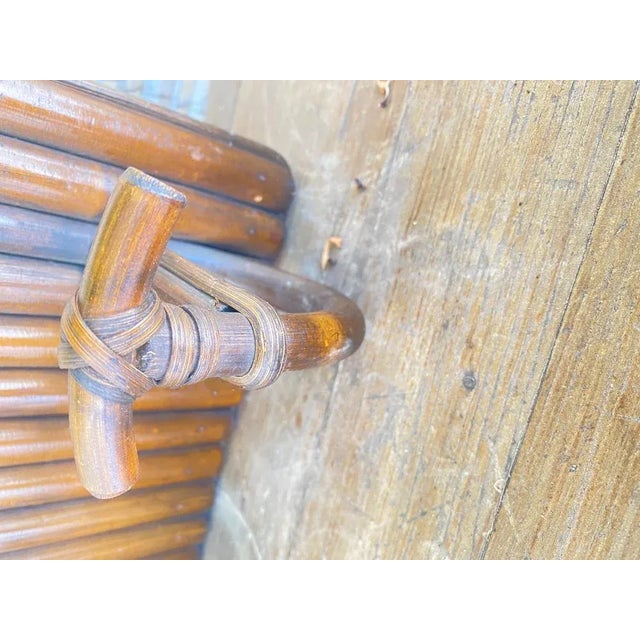 Wall-mounted coat rack with two hooks in wood with bamboo hat rack attached. It is brown in color. It was made in France...