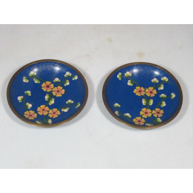 Set of Chinese brass and enamel cloisonné catchalls. They are decorated with pink floral designs on deep blue and black...