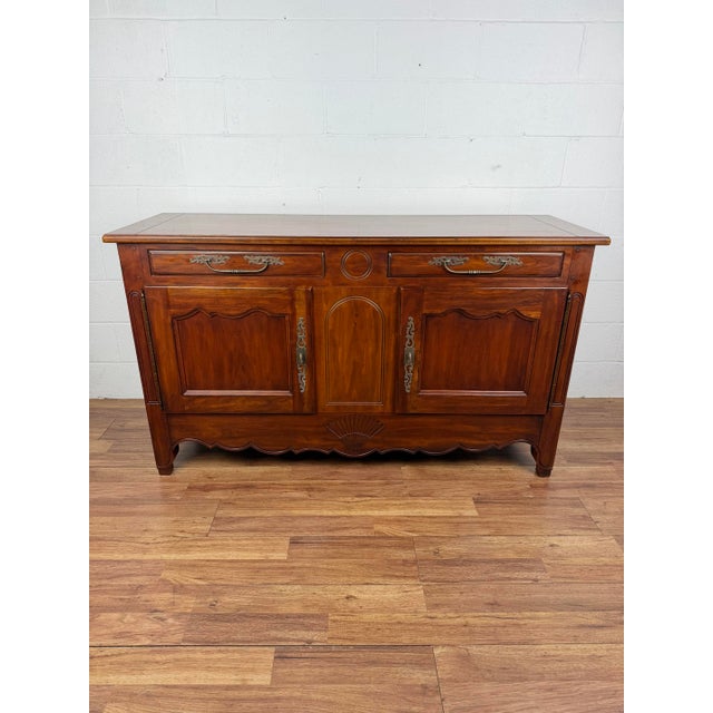 French Provincial style console cabinet by Drexel Heritage, the banded top surmounting two drawers over two cabinet doors...