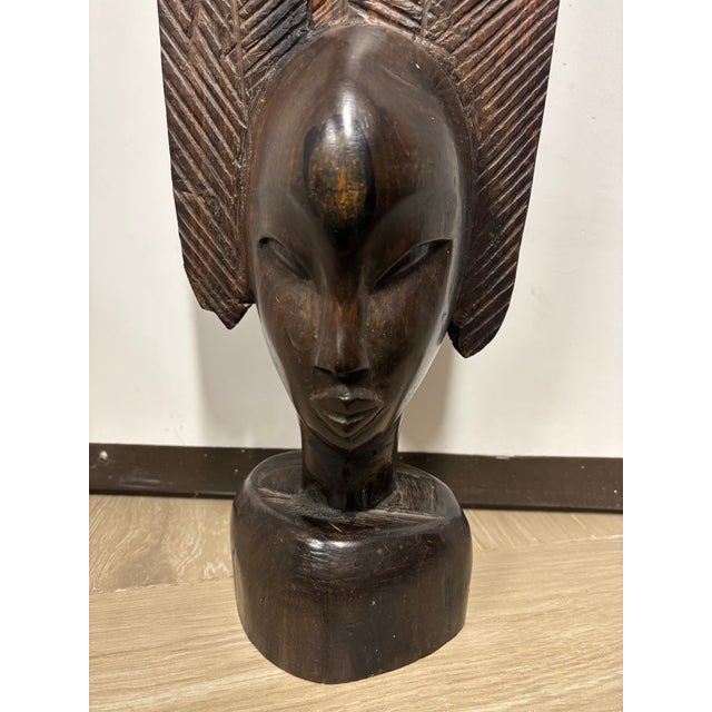 Striking mid-century carved female bust sculpted from dense ebony hardwood, featuring an elongated modernist form and...