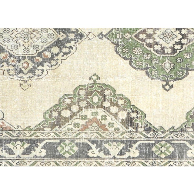 A vintage Turkish Oushak measuring 4'8" x 12'6", hand-woven with wool on wool foundation. This piece displays the region's...