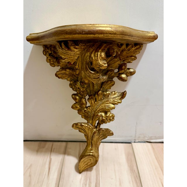Palladio hand carved gilded wood decorative wall shelf. Neoclassic design with leaves, branches, and other foliage. Great...