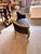 A dramatic French Louis XV-style canapé loveseat with a richly carved gilt frame, deep black upholstery, and a beautifully...