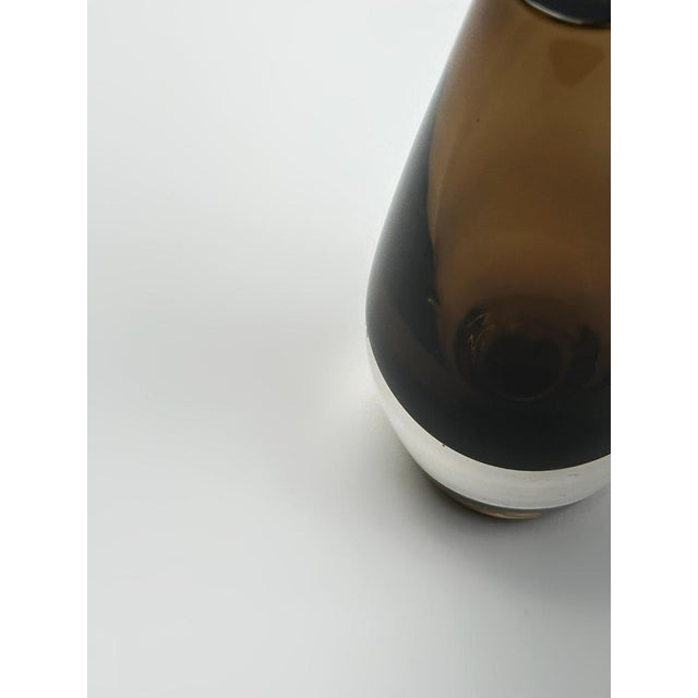 A small mid-century Swedish smoked glass bud vase by Strömbergshyttan. Modernist in style, the vase is crafted from thick-...