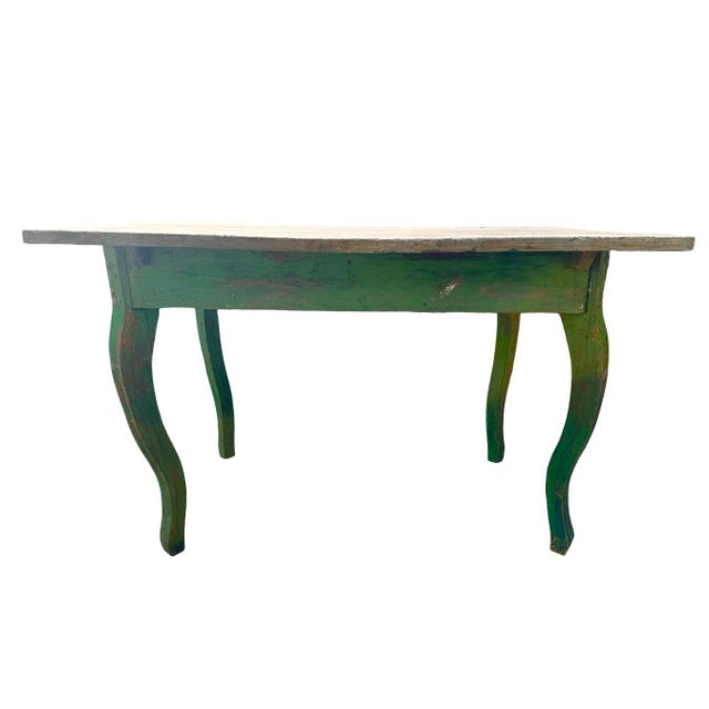 Charming and full of character, this antique rustic desk features a beautifully weathered green painted finish with...