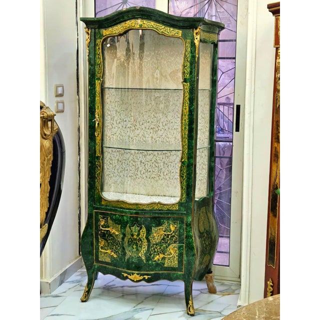 Make a dramatic statement with this exquisite Emerald Green Curio Cabinet, a luxurious display piece crafted with an...