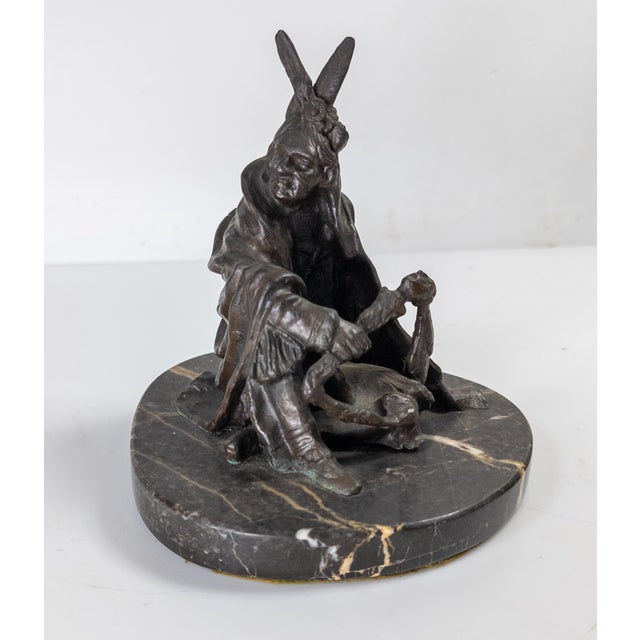 We are selling this decorative Western bronze of a seated Indian. This bronze of a seated Indian holding a staff is after...