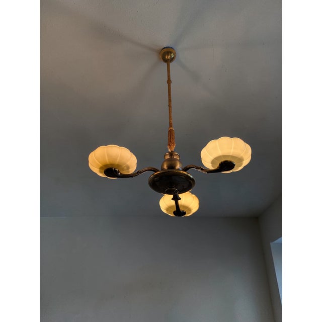 This stunning and rare Paavo Tynell three-arm chandelier is a true jewel of Finnish design history. The lamp represents...