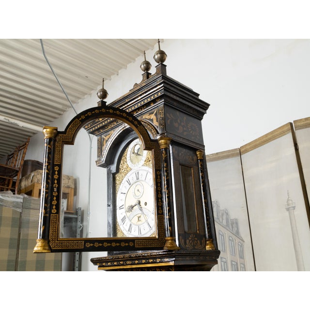 An English George III period Chinoiserie parcel gilt and japanned tall case clock from the 18th century, with black paint...