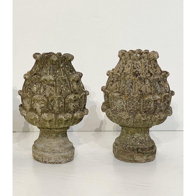 A pair of two Italian garden ornamental statuary finials of composition stone - both lightly weathered and in the form of...