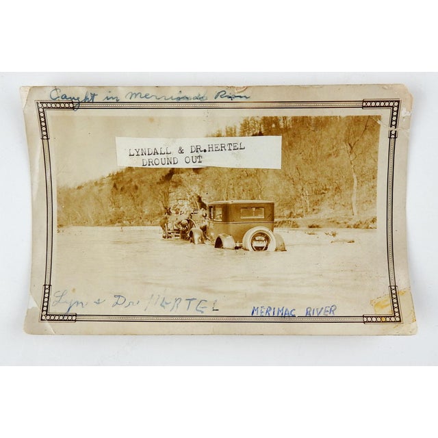 Vintage circa 1920's sepia toned snapshot photograph of a car stuck in the Merimac River, being pulled out by a wagon. Ink...