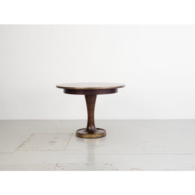 A round wooden ship's table with brass details, attributed to Gustavo Pulitzer-Finali (1887–1967). The table features a...