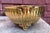 This is a vintage solid brass centerpiece or planter bowl featuring a ribbed body, decorative handles, and ornate feet....