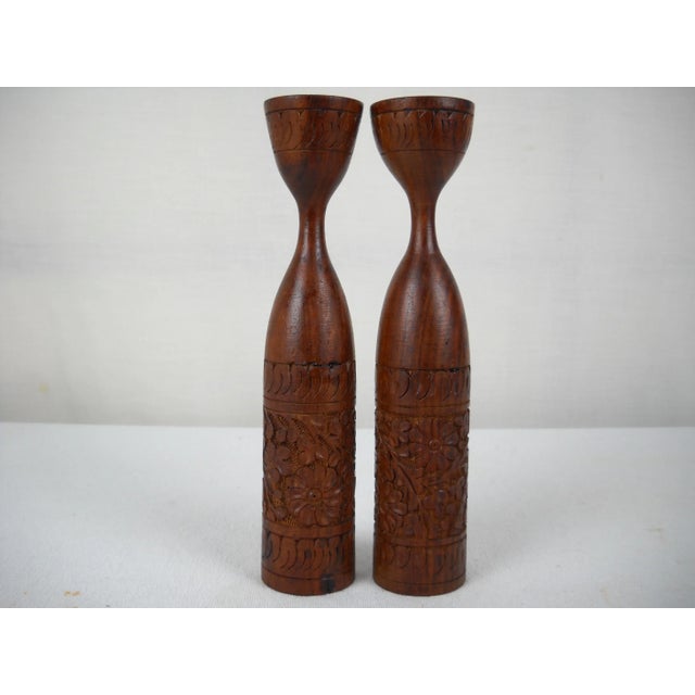 Pair of Mid-century Indonesian carved teak candle holders. Sleek Mid-century design featuring hand-carved floral...