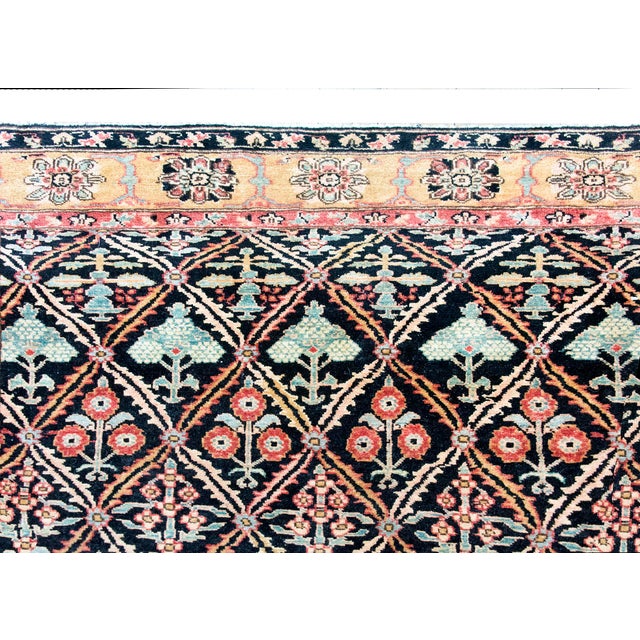 This vintage hand-woven wool rug features a classic Heriz-inspired design with a dense geometric lattice across a dark...
