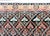 This vintage hand-woven wool rug features a classic Heriz-inspired design with a dense geometric lattice across a dark...