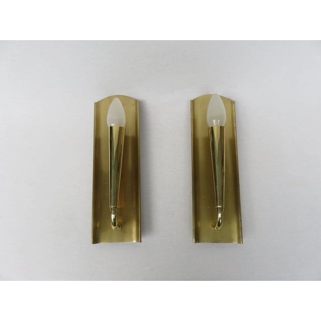 A pair of elegant yet minimalist wall lights from the 50s. They are made of high quality brass. Polished brass was...