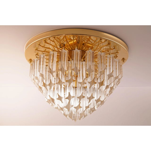 This six-tiered vintage flush mount was manufactured by Venini in Italy. The lamp has clear Murano glass pieces of varying...