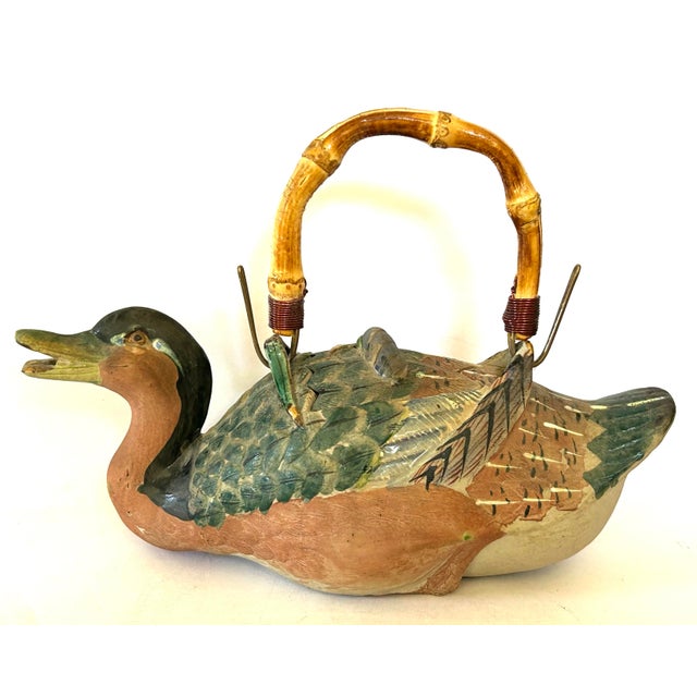 Charming Asian teapot in the style of a duck swimming through the reeds and iris. Lovely detail down to its webbed feet....