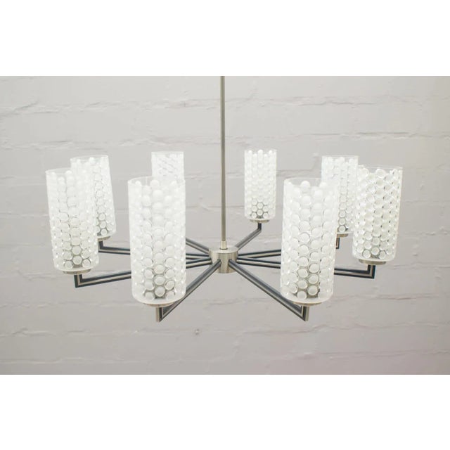 This vintage chandelier from Kaiser Leuchten features eight cylindrical glass shades with E27 bulb sockets. This piece has...