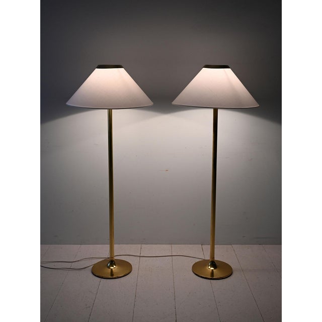Vintage Scandinavian floor lamps, 1950s-1970s, in brass with conical lampshade. Elegant pair of Scandinavian floor lamps,...
