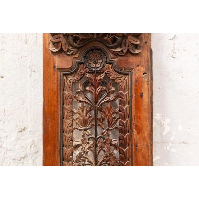 Panel belonging to a door or window closure made of teak wood with floral decoration in medium and high relief.