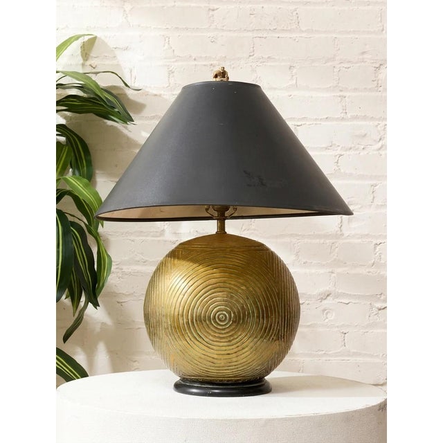 A distinctive vintage table lamp combining a dramatically oversized black tapered shade with an expressive sculptural...