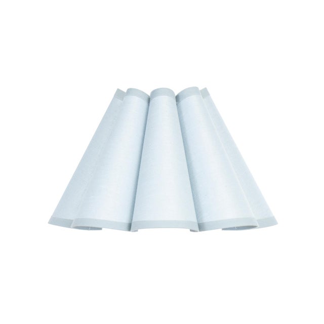 Crafted from linen in a soft Mist Blue hue, the Polly Alternate Shade features a gently scalloped form that adds quiet...