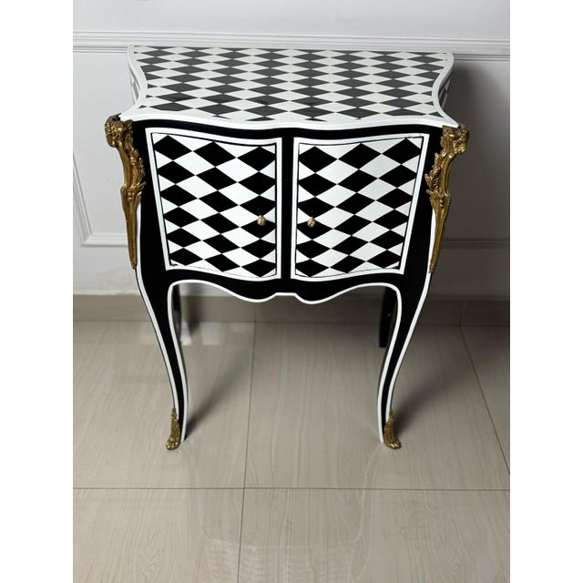 A Louis XV courtly checkered table with storage in a black, white, and gold color scheme would be a luxurious and opulent...