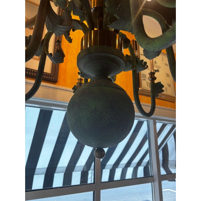 Green and brass nine light chandelier. Curling leaf details. 32 in height does not include full drop.