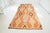 This is a vintage Turkish Oushak rug from the Mid 20th Century. The piece was hand-knotted.
