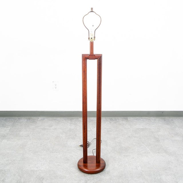 A mid century modern designed Mahogany floor lamp. Lamp is tested and works well. Unique and well constructed.