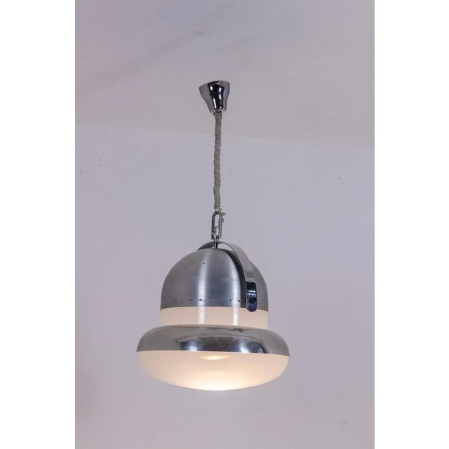 Industrial style pendant light in brushed and opaline white metal, circular in shape. Italian work realized in the 1970s....
