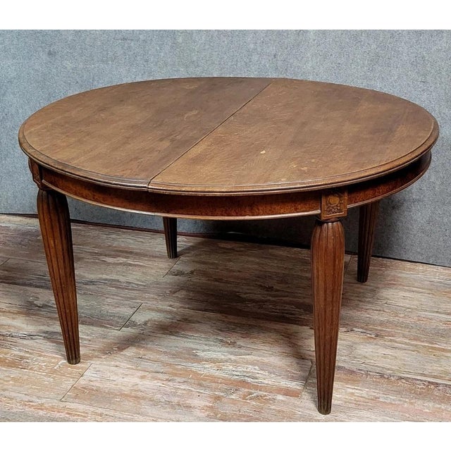 Art Deco extendable table in stained oak and burl veneer, circa 1925 Decorated with carvings Flushed, pointed legs Sold...