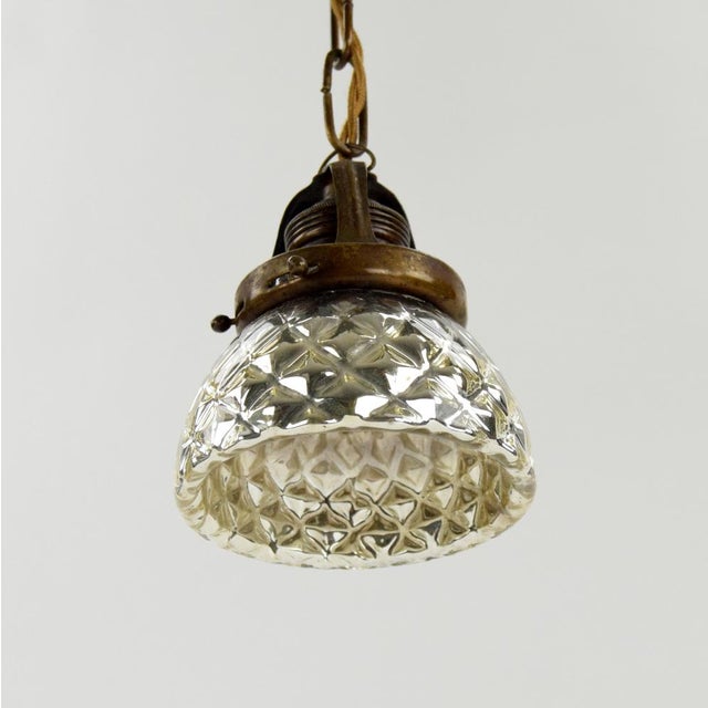 An intriguing pendant light made of mercury glass, which was once used above counters in goldsmiths’ and jewelers’ shops...