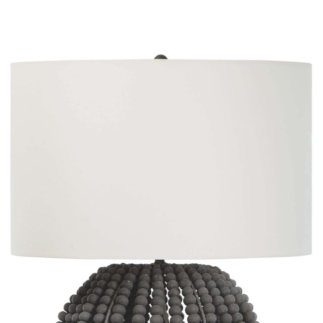 Coastal style meets modern charm with the Tropez table lamp. A bevy of draped charcoal grey wooden beads, dresses up the...