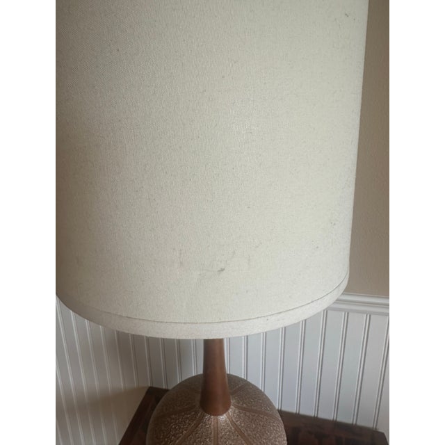 Tan and Ivory ceramic lamp with a lava glaze texture and stipe pattern. Accented by a walnut base and neck and the...