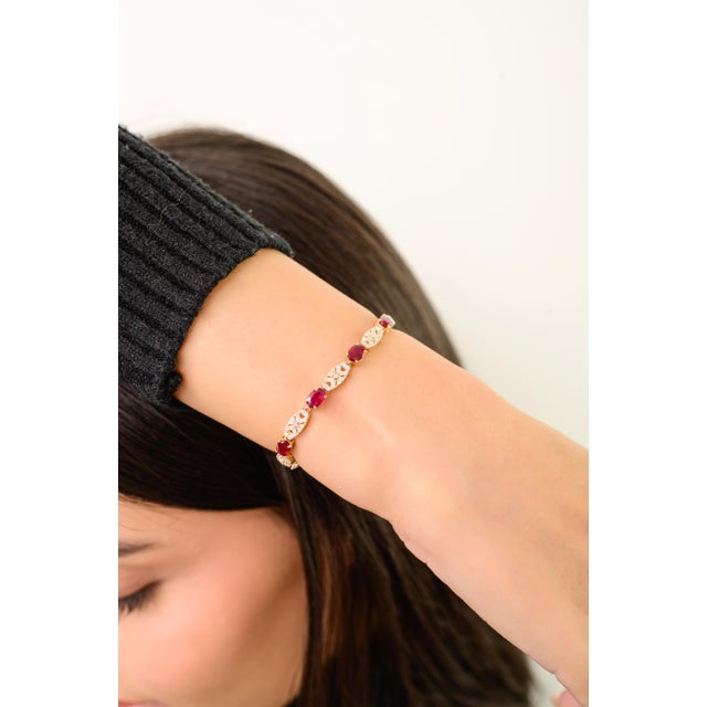 This handcrafted tennis bracelet features 11 oval-cut natural rubies totaling 5.02 carats, set in 14k yellow gold. each...