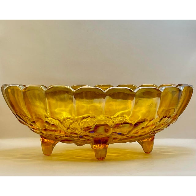 An iridescent amber glass footed bowl made by the Indiana Glass Company and decorated with bunches of fruit.
