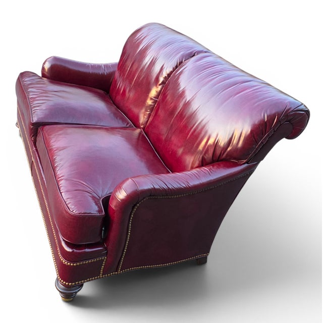 A handsome Hickory Chair "Historical James River Plantation" loveseat upholstered in rich oxblood leather with a...
